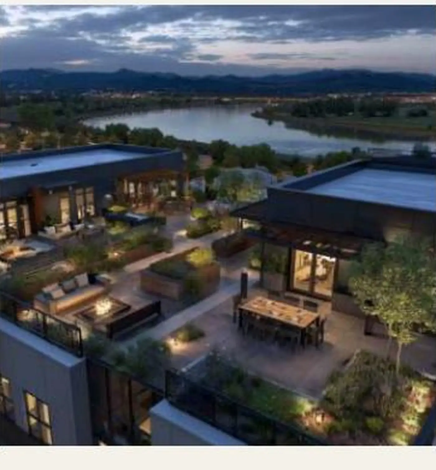 A Pacific Northwest valley at dusk, with mountains in the distance and a green-roofed terrace in the foreground.